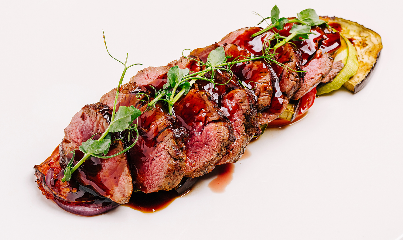 Grilled beef tenderloin slices with sauce and vegetables