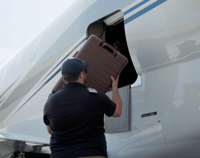 FlightWorks crew member loading luggage into a managed private jet