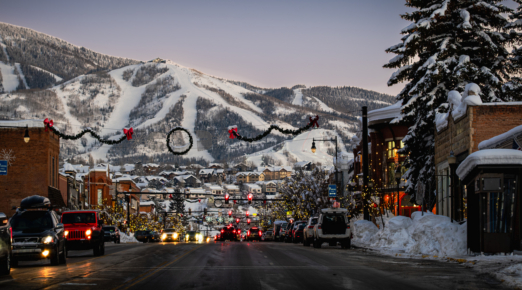 View of main street of old American town turned ski resort decorated with christmas lights in early evening