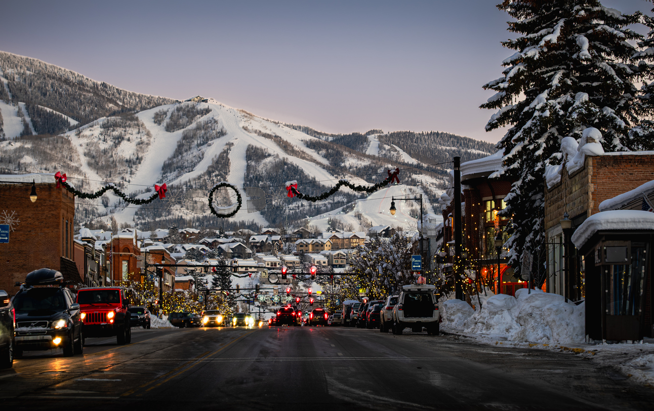View of main street of old American town turned ski resort decorated with christmas lights in early evening